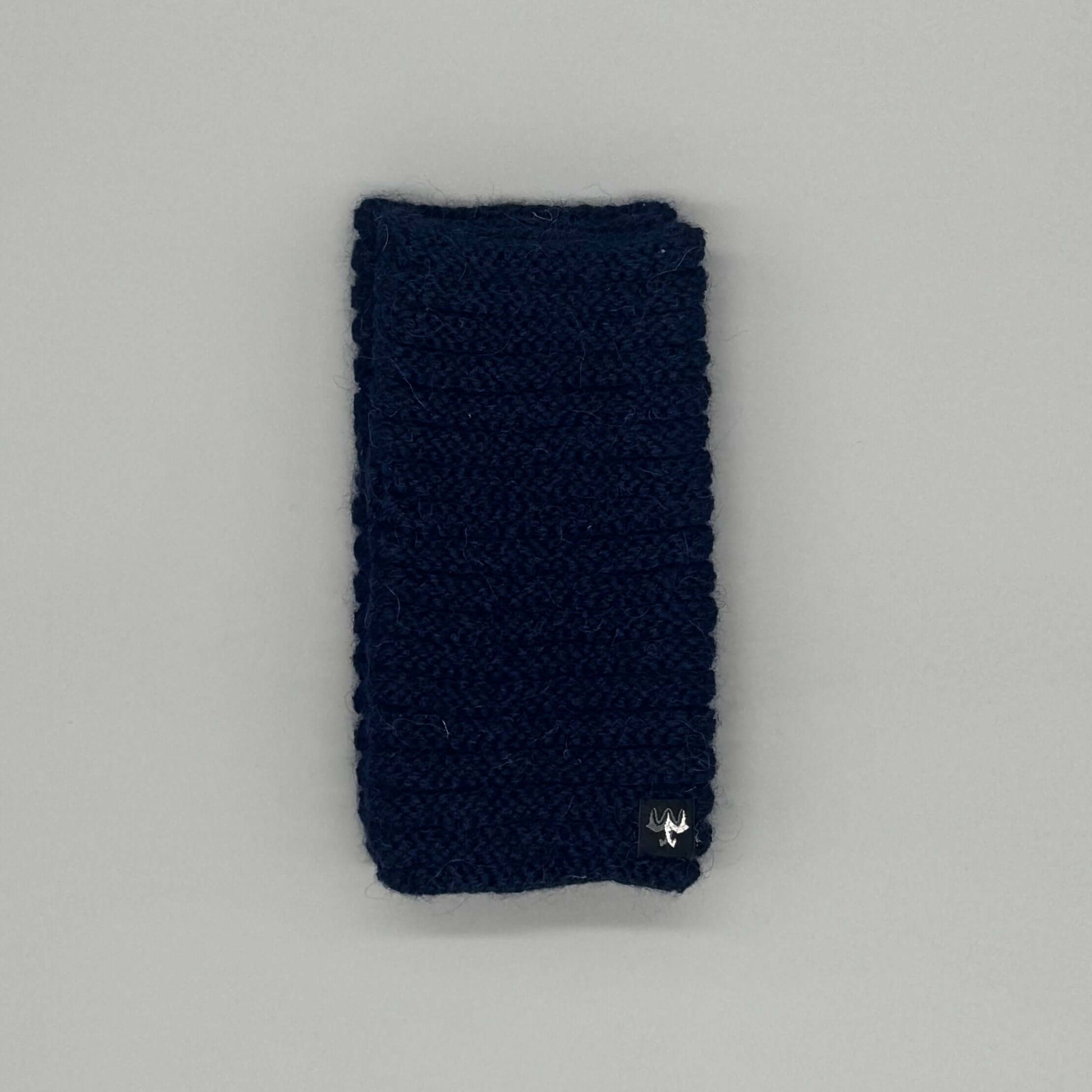 Alpaka Pulswärmer aus Baby-Alpakawolle im Röllchenmuster in Navy auf grauem Hintergrund.